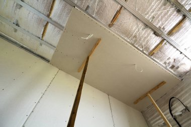İnşaat ve tadilat gümüş alüminyum izolasyon folyo ile altında bitmemiş Oda görüş açısı duvarlar ve tavan ve alçıpan tahta çerçeveye bağlı. Yeniden yapılanma ve yenileme kavramı.