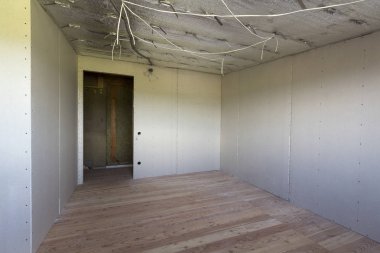 Büyük boş oda altında inşaat ve yenileme ile gümüş alüminyum folyo duvarlar ve tavan, elektrik telleri çıktı, meşe zemin ve duvar. Profesyonel yeniden yapılanma ve izolasyon kavramı.