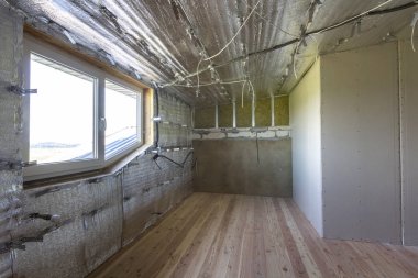 Büyük boş oda altında inşaat ve yenileme ile gümüş alüminyum folyo duvarlar ve tavan, elektrik telleri çıktı, meşe zemin ve duvar. Profesyonel yeniden yapılanma ve izolasyon kavramı.