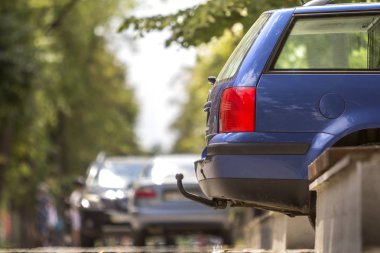 Mavi araba detayını görmek güneşli Caddesi, kırmızı dur ışıkları ve treyler, çekici aksaklık veya römork bulanık kopya alan arka plan üzerinde sürüklemek için kanca park etmiş. Ulaşım tasarım ve güvenlik.