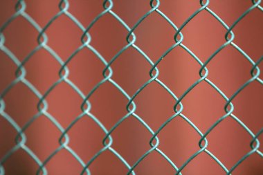 İzole boyalı basit geometrik siyah demir metal tel zincir bağlantı çit eon koyu kırmızı zemin Close-up. Çit, koruma ve muhafaza kavramı.