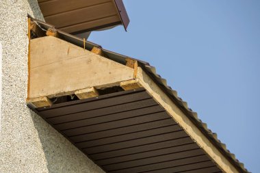 Alt görünümü ayrıntılı yeni modern ev yazlık köşesinde sıva duvarlar ile çatı ve bitmemiş siding yükleme açık mavi gökyüzü kopya alan arka plan üzerinde kahverengi shingled. Emlak kavramı.