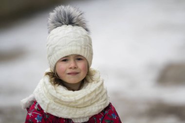 Sevimli küçük genç komik güzel sarışın güzel sıcak kış giyim beyaz parlak gri gözlü bulanık kız açık havada kopya alan arka plan gülümseyen portresi. Çocukluk kavramının güzellik.