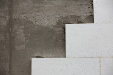 Sert köpük yalıtım ile sıvalı ev duvar detay yakın çekim. Modern teknoloji, inşaat, tadilat, enerji tasarrufu, alternatif mineral yün, sıcak rahat ev kavramı için.