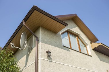 Dekoratif lamba ve uydu çanağı sıva duvarlar, plastik tavan penceresi, mavi gökyüzü kopya alan arka plan üzerinde oluk boru sistemi ile yeni modern ev üst alt görünümü ayrıntı. Emlak kavramı.