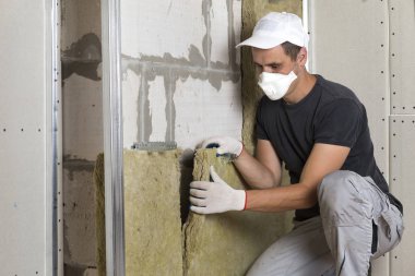 Ahşap çerçeve için soğuk bariyer için gelecekteki ev duvarları taş yünü izolasyon yalıtım Koruyucu solunum maskesi işçi. Rahat sıcak ev, ekonomi, inşaat ve tadilat kavramı