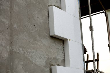 Sert köpük yalıtım ile sıvalı ev duvar detay yakın çekim. Modern teknoloji, inşaat, tadilat, enerji tasarrufu, alternatif mineral yün, sıcak rahat ev kavramı için.