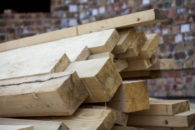 Parlak güneş tarafından yaktı doğal kahverengi düzensiz kaba ahşap Komiteler Kazıklı yığını Close-up. Endüstriyel ahşap marangozluk, bina, onarım ve mobilya, İnşaat için kereste malzeme için.