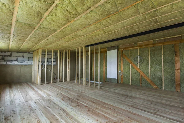 Yapım ve yenileme büyük geniş meşe zemin, duvar ve tavan taş yünü ve soğuk bariyer için cam elyaf ve gelecekteki duvarlar için ahşap çerçeve ile bitmemiş tavan arası Oda boş.