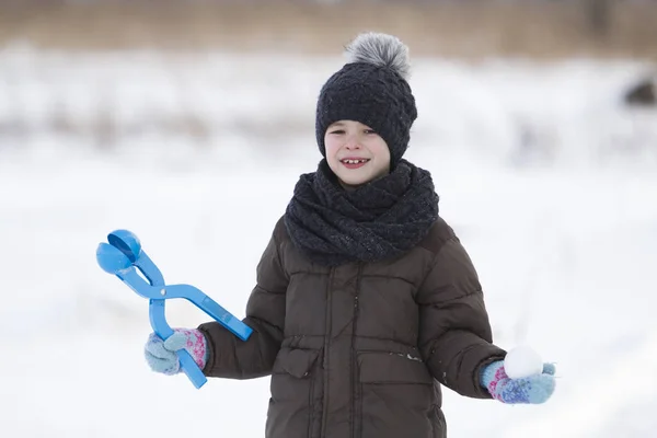 可爱的小年轻滑稽的无牙齿的孩子在温暖的衣服玩有乐趣做雪球在冬季寒冷的天白色明亮模糊复制空间背景 户外活动 假日游戏 — 图库照片