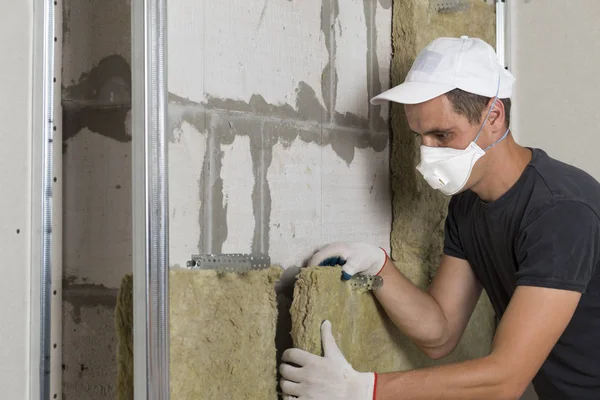 Ahşap çerçeve için soğuk bariyer için gelecekteki ev duvarları taş yünü izolasyon yalıtım Koruyucu solunum maskesi işçi. Rahat sıcak ev, ekonomi, inşaat ve tadilat kavramı