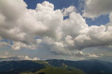 Derin mavi yaz gökyüzü karşı yeşil dağ sırtı üzerinde yayılan güneş tarafından parlak beyaz bulutlar fantastik panorama görünümünü yaktı. Güzellik ve güç doğa, meteoroloji ve iklim kavramı değiştirme.