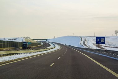 Ufuk yüksek köprü dönüm değil uzak orman geçmiş gün altında uzanan Modern geniş düz boş asfalt karayolu. Hız, rahat yolculuk ve profesyonel yol kavram bina.
