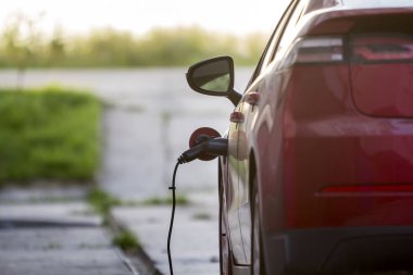 Kiev, Ukrayna - 9 Nisan 2018: Yakın çekim detayını parlak elektrikli araba parlak güneşli banliyösü sokak arka plan üzerinde şarj. Prizine takılı şarj kablosu. Modern ecofriendly teknoloji kavramı.