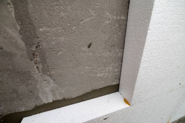 Sert köpük yalıtım ile sıvalı ev duvar detay yakın çekim. Modern teknoloji, inşaat, tadilat, enerji tasarrufu, alternatif mineral yün, sıcak rahat ev kavramı için.