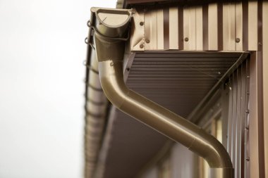 Yakın çekim detay metal plakalar dış cephe kaplaması ile yazlık ev köşe ve çatı çelik cilt payı yağmur sistemi ile. Dayanıklılık, profesyonel inşaat, drenaj boruları kurulum ve bağlantı kavramı.