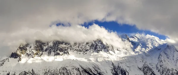 冬の日の光沢のある雪 氷河クリア冷日当たりの良いアルプスのフランス側にふくらんでいる白い雲と青い空の下で覆われてモンブラン山頂の息を呑む空撮 — ストック写真
