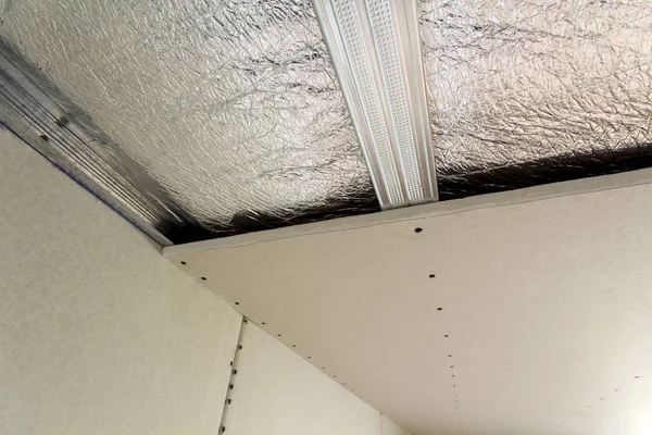 クローズ アップ底面未完成の建設 改修銀アルミホイル絶縁材と乾式壁の下の部屋の壁や天井に プロの仕事と改修のコンセプト — ストック写真