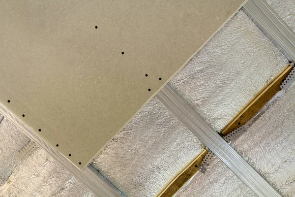 クローズ アップ底面未完成の建設 改修銀アルミホイル絶縁材と乾式壁の下の部屋の壁や天井に プロの仕事と改修のコンセプト — ストック写真