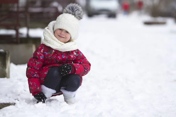 可爱的小小滑稽微笑的女孩的肖像在漂亮温暖的衣服玩在雪中享受在冬天寒冷的日子在白色明亮模糊的复制空间背景的乐趣 户外活动和游戏 — 图库照片