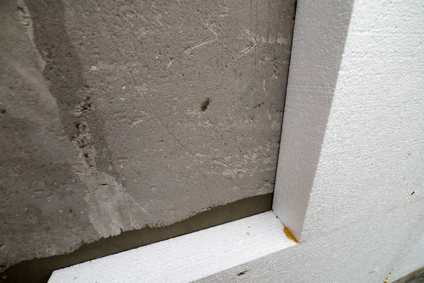 Sert köpük yalıtım ile sıvalı ev duvar detay yakın çekim. Modern teknoloji, inşaat, tadilat, enerji tasarrufu, alternatif mineral yün, sıcak rahat ev kavramı için.