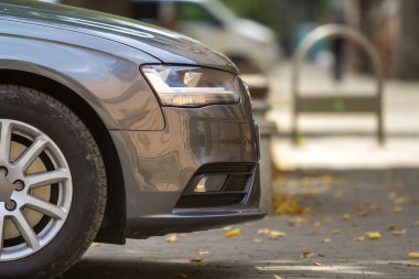 Kiev, Ukrayna - 9 Temmuz 2018: Yan görünüm yeşillik bokeh arka plan üzerinde gölgeli yeşil ağaç altında döşeli güneşli Caddesi üzerinde park edilmiş modern gümüş parlak araba. Ulaşım, hız, zerafet, lüks konsepti.