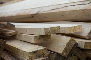 Parlak güneş tarafından yaktı doğal kahverengi düzensiz kaba ahşap Komiteler Kazıklı yığını Close-up. Endüstriyel ahşap marangozluk, bina, onarım ve mobilya, İnşaat için kereste malzeme için.