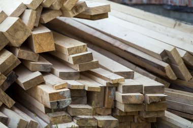 Parlak güneş tarafından yaktı doğal kahverengi düzensiz kaba ahşap Komiteler Kazıklı yığını Close-up. Endüstriyel ahşap marangozluk, bina, onarım ve mobilya, İnşaat için kereste malzeme için.