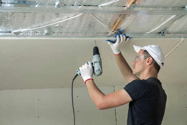 Молодой Человек Очках Прикрепляет Подвесный Потолок Металлической Раме Помощью Электрической — стоковое фото