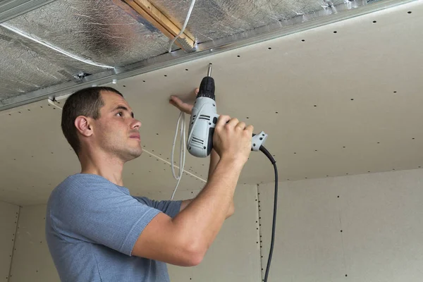 Jonge Man Gebruikt Elektrische Schroevendraaier Vaststelling Van Gipsplaten Geschorst Plafond — Stockfoto