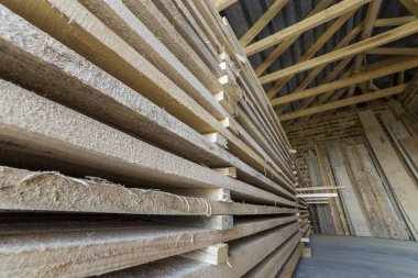 Kurulların doğal kahverengi düzensiz kaba ahşap tavan odada yapım aşamasında düzgünce Kazıklı yığın Close-up. Endüstriyel ahşap marangozluk, yapı, İnşaat için kereste malzeme için.