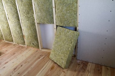 Alçıpan plakalar ile gelecekteki duvarlar için ahşap çerçeve kaya yünü ve fiberglas ile yalıtım personel soğuk bariyer için yalıtılmış. Rahat sıcak ev, ekonomi, inşaat ve tadilat kavramı.