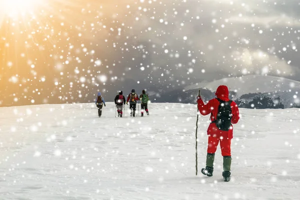 Turistas Excursionistas Invierno Montañas Cubiertas Nieve Nubes Dramáticas Cielo —  Fotos de Stock