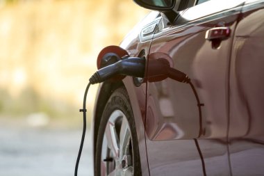 Kiev, Ukrayna - 9 Nisan 2018: Yakın çekim detayını parlak elektrikli araba parlak güneşli banliyösü sokak arka plan üzerinde şarj. Prizine takılı şarj kablosu. Modern ecofriendly teknoloji kavramı.