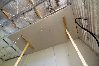 İnşaat ve tadilat gümüş alüminyum izolasyon folyo ile altında bitmemiş Oda görüş açısı duvarlar ve tavan ve alçıpan tahta çerçeveye bağlı. Yeniden yapılanma ve yenileme kavramı.