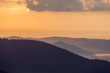 Geniş panorama, fantastik görünümünü parlak açık turuncu gökyüzü kopya alan arka plan üzerinde gün batımında sabah sis yeşil Karpat Dağları ile kaplı. Güzellik, Doğa, turizm ve seyahat kavramı.