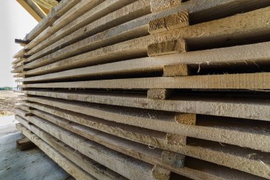 Kurulların doğal kahverengi düzensiz kaba ahşap tavan odada yapım aşamasında düzgünce Kazıklı yığın Close-up. Endüstriyel ahşap marangozluk, yapı, İnşaat için kereste malzeme için.