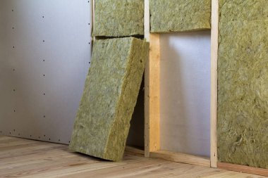 Alçıpan plakalar ile gelecekteki duvarlar için ahşap çerçeve kaya yünü ve fiberglas ile yalıtım personel soğuk bariyer için yalıtılmış. Rahat sıcak ev, ekonomi, inşaat ve tadilat kavramı.