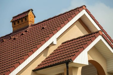 Detay büyük modern pahalı konut yazlık dik shingled çatı, tuğla baca ile top, mavi gökyüzü arka plan duvarlarda sıva. İnşaat, profesyonel çatı kaplama ve yatırım kavramı.