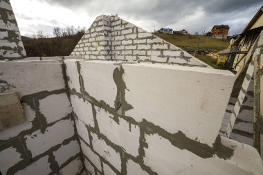 Yukarıdan gelecek yazlık enerji tasarrufu büyük beyaz içi boş köpük yalıtım blokları ve geçici ahşap iskele çerçeve. İnşaat ve duvar, teknoloji kavramı bina modern.