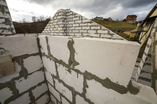 Yukarıdan gelecek yazlık enerji tasarrufu büyük beyaz içi boş köpük yalıtım blokları ve geçici ahşap iskele çerçeve. İnşaat ve duvar, teknoloji kavramı bina modern.