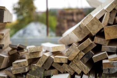 Parlak güneş tarafından yaktı doğal kahverengi düzensiz kaba ahşap Komiteler Kazıklı yığını Close-up. Endüstriyel ahşap marangozluk, bina, onarım ve mobilya, İnşaat için kereste malzeme için.