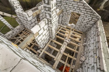 Gelecekteki yazlık, enerji tasarrufu büyük beyaz içi boş köpük yalıtım blokları ve geçici ahşap iskele çerçeve duvarlarının iç. İnşaat, duvarcılık, modern teknoloji kavramı.