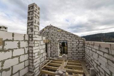 Gelecekteki yazlık, enerji tasarrufu mavi gökyüzü ve odunsu hills kopya alan arka plan duvar ve baca büyük beyaz içi boş köpük yalıtım iç. İnşaat, duvarcılık, modern teknoloji kavramı.