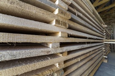 Kurulların doğal kahverengi düzensiz kaba ahşap tavan odada yapım aşamasında düzgünce Kazıklı yığın Close-up. Endüstriyel ahşap marangozluk, yapı, İnşaat için kereste malzeme için.