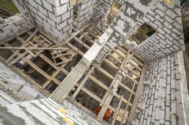 Yukarıdan gelecekteki multi depolanan yazlık enerji tasarrufu büyük beyaz içi boş köpük yalıtım blokları ve geçici ahşap iskele çerçeve görüntüleyin. İnşaat duvar, modern teknoloji kavramı.