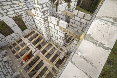 Yukarıdan gelecekteki multi depolanan yazlık enerji tasarrufu büyük beyaz içi boş köpük yalıtım blokları ve geçici ahşap iskele çerçeve görüntüleyin. İnşaat duvar, modern teknoloji kavramı.