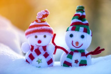 İki küçük komik oyuncak bebek kardan adam örgü şapkalı ve eşarplı açık havada açık havada açık mavi ve beyaz fotokopi arkaplanda. Mutlu yıllar ve Mutlu Noeller tebrik kartı.