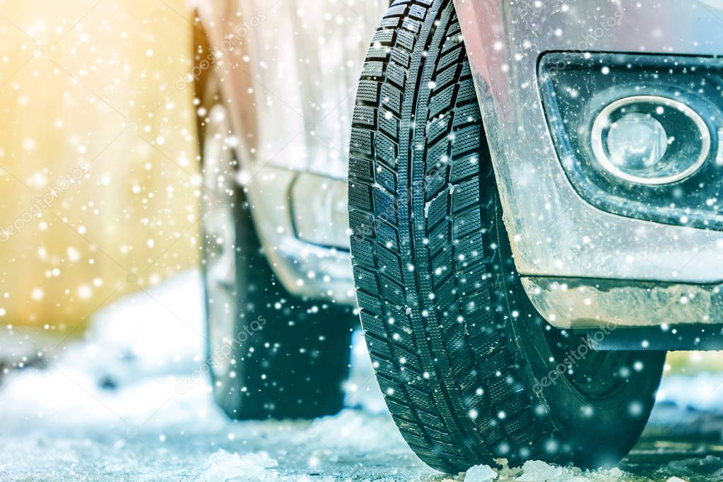 Close-up of car wheel in winter tire on snowy road