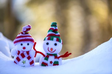 İki küçük komik oyuncak bebek kardan adam örgü şapkalı ve eşarplı açık havada açık havada açık mavi ve beyaz fotokopi arkaplanda. Mutlu yıllar ve Mutlu Noeller tebrik kartı.